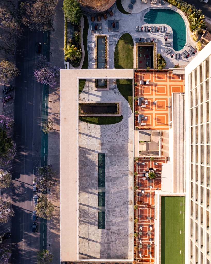 Drone shot over Four Seasons Hotel Ritz Lisbon’s rooftop terrace and swimming pool, with its geometric gardens and a city street below