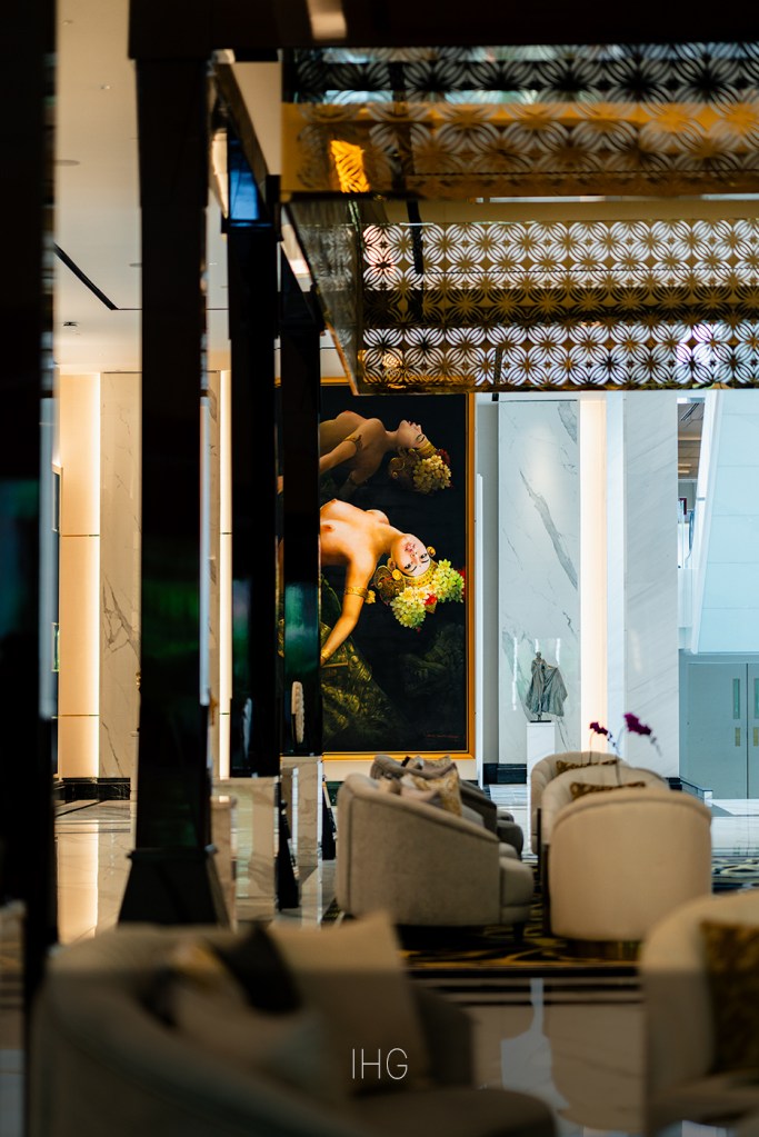 nterior lounge at InterContinental Bali with marble columns, patterned metal ceiling panels, and a large framed artwork above soft seating